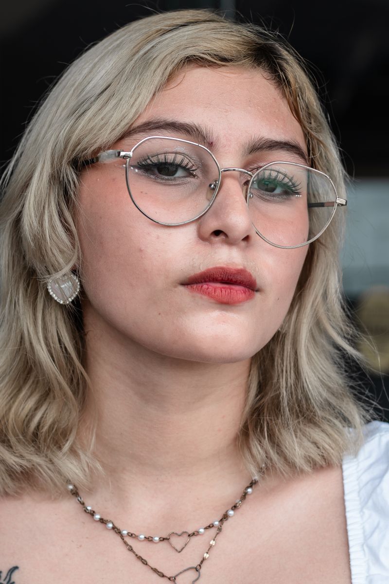 A person with a heart face shape wearing glasses